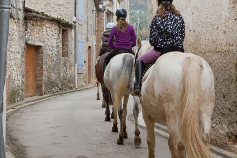 jeunes cavalières en promenade dans une rue d'un village