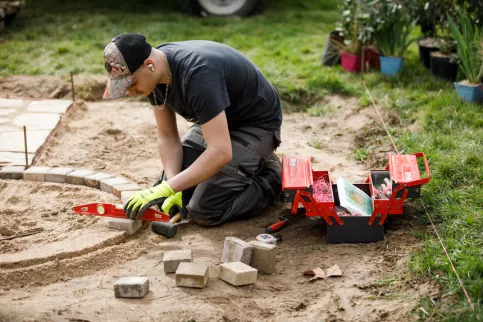 Jeune à genoux travaillant sur une scène paysagère