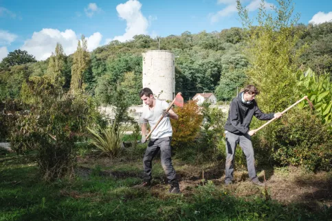 Deux jeunes en formation en train de travailler dans les jardins du campus